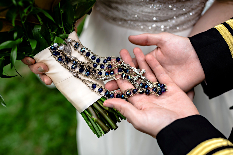 Rosary beads tied to the brides wedding bouquet.